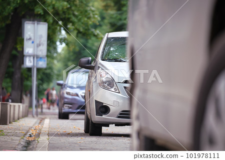 City traffic with cars parked in line on street side City traffic with cars parked in line on street side 101978111