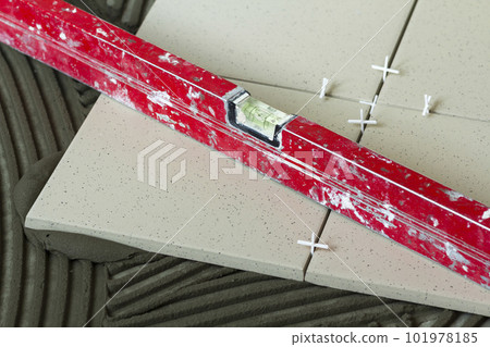 Ceramic tiles and tools for tiler. Floor tiles installation. Home improvement, renovation - ceramic tile floor adhesive Ceramic tiles and tools for tiler. Floor tiles installation. Home improvement, renovation - ceramic tile floor adhesive 101978185