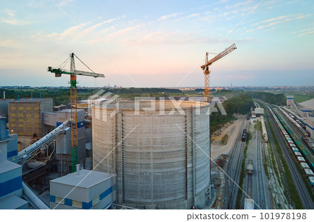Cement plant with high factory structure and tower cranes at industrial production area. Manufacture and global industry concept 101978198