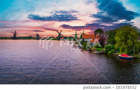 Sunset above farm houses and windmills of Zaanse Schans in the Netherlands 101978552