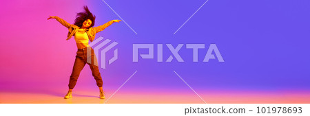 Young girl in sport style clothes dancing hip-hop against gradient pink purple background in neon light 101978693