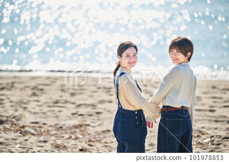 好年輕女人和她的朋友在海灘手挽手 101978853
