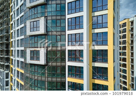 Architectural details of modern high apartment building facade with many windows and balconies Architectural details of modern high apartment building facade with many windows and balconies 101979018