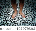 Bare feet on dried and cracked soil surface. 101979308