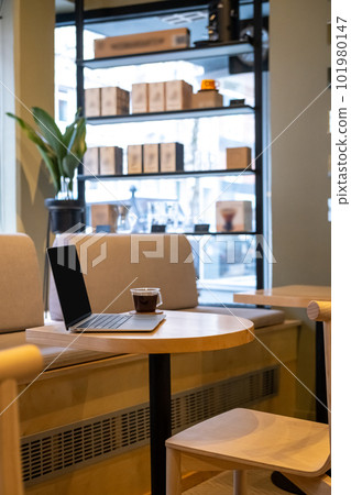 Black coffee and a portable computer on the cafe table 101980147