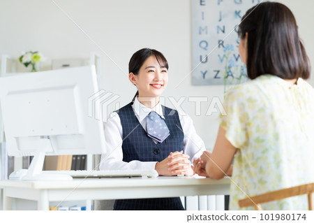 A young business woman consulting a young woman A young business woman consulting a young woman 101980174