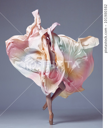 Young girl, ballerina dancing with elegance movements and fabric cover the face over grey studio background. Ballet with silk fabric 101980382