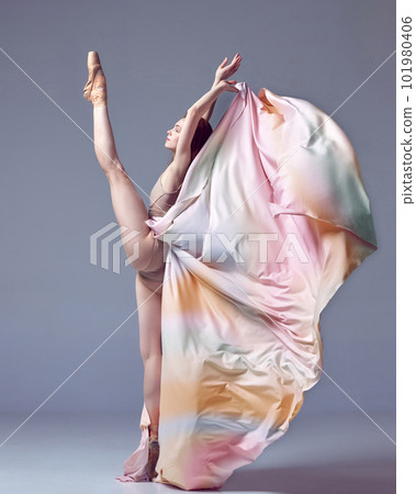 Portrait with charming ballerina wearing colorful long dress and dancing with emotions over grey studio background. Side view. Inspiration 101980406