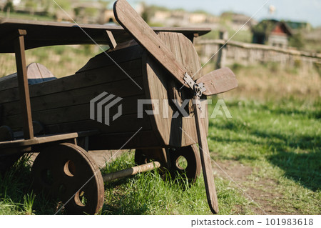 A wooden model of an airplane standing on the street in summer A wooden model of an airplane standing on the street in summer 101983618