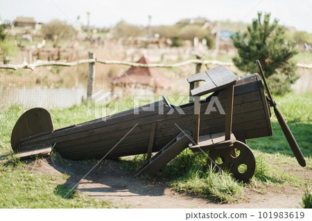 A wooden model of an airplane standing on the street in summer 101983619