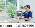 Caucasian patient using laptop in hospital room. man sick patient lying in a hospital bed 101984460