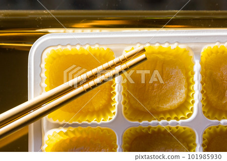 Yellow mango and lemon mochi mochies, wooden chopsticks on a golden tray top view. Asian food, sweets and delicacies. Japanese traditional confectionary ice cream made of rice flour dough. Soft focus. 101985930