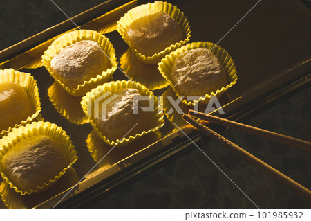 Yellow mango and lemon mochi mochies, wooden chopsticks on a golden tray top view. Asian food, sweets and delicacies. Japanese traditional confectionary ice cream made of rice flour dough. Soft focus. Yellow mango and lemon mochi mochies, wooden chopsticks on a golden tray top view. Asian food, sweets and delicacies. Japanese traditional confectionary ice cream made of rice flour dough. Soft focus. 101985932