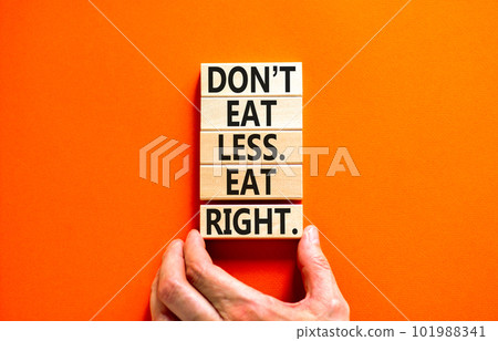 Eat less or right symbol. Concept words Do not eat less, eat right on wooden blocks. Beautiful orange table orange background. Doctor hand. Healthy lifestyle and eat less or right concept. Copy space. 101988341