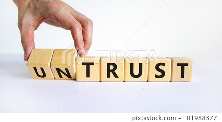 Untrust or trust symbol. Businessman turns wooden cubes, changes words 'untrust' to 'trust'. Beautiful white table, white background. Business and untrust or trust concept, copy space. 101988377