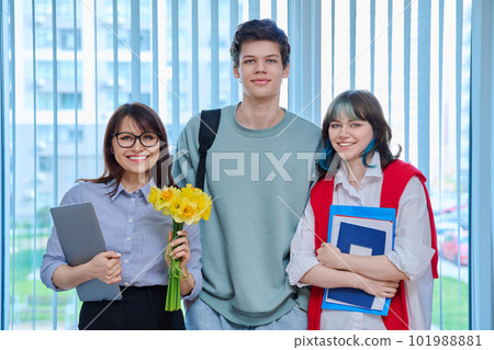 Teenage students congratulating female teacher with bouquet of flowers 101988881