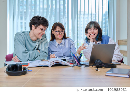 College students with teacher sitting at desk in classroom studying languages, sciences 101988981