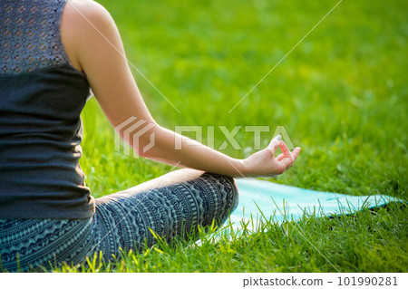 Young woman doing yoga exercises in the summer city park. 101990281