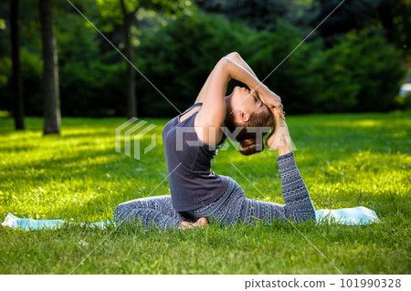Young woman doing yoga exercises in the summer city park. Young woman doing yoga exercises in the summer city park. 101990328