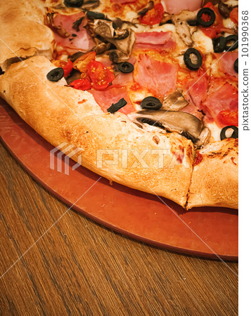 Pizza capriciosa with cheese stuffed crust in pizzeria, food 101990368