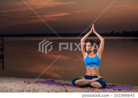 yoga at sunset on the beach. 101990645