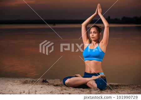 yoga at sunset on the beach. 101990729