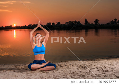 yoga at sunset on the beach. 101991277