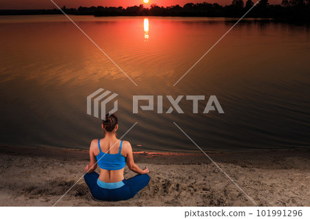 yoga at sunset on the beach. 101991296