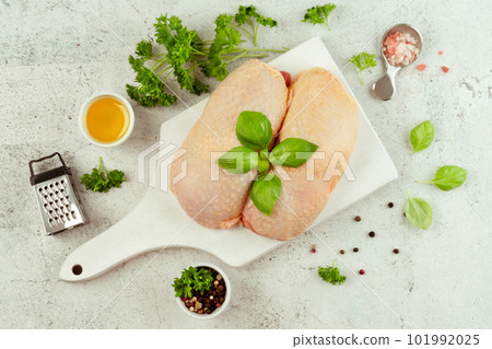 Food for retail.Procurement for designers.Ogranic food,healthy eating.Food concept.Top view.Chicken leg meat.Raw fresh chicken leg meat with skin on a light background with fresh herbs. 101992025