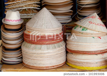 Straw hats for sale on a market stall 101993006