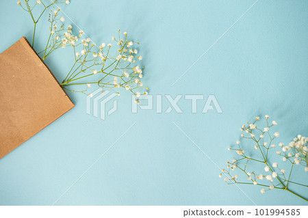 Top view of a blue table with gypsophila flowers in a craft package 101994585
