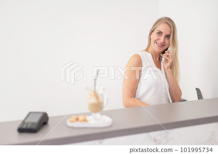 Receptionist in a beauty salon talking to a client on the phone. Receptionist in a beauty salon talking to a client on the phone. 101995734