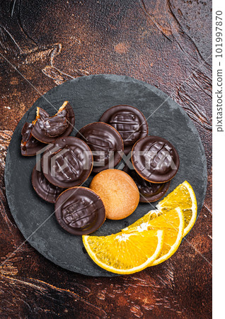 Stack of Chocolate Covered Round Jaffa Cookies with Orange Flavored Marmalade. Dark background. Top view 101997870