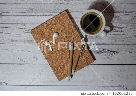 Top view, wooden Office desk with cup of coffee, eco pen, wireless headphones and recycle notebook. Business or student workspace concept Flat lay. Personal diary Audio healing, sound mental health Top view, wooden Office desk with cup of coffee, eco pen, wireless headphones and recycle notebook. Business or student workspace concept Flat lay. Personal diary Audio healing, sound mental health 102001252