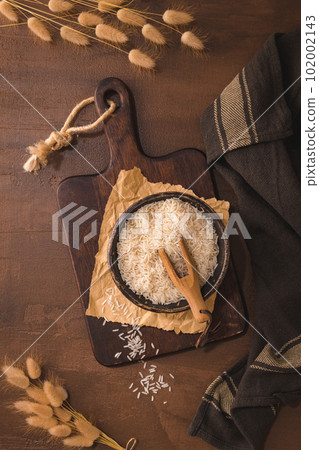 Long grain rice on rustic countertop Long grain rice on rustic countertop 102002143