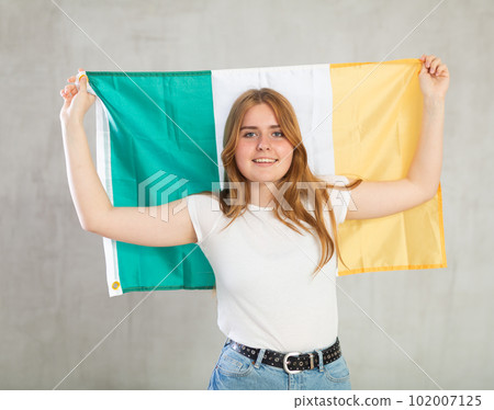 smiling girl in arms raised above head holds canvas of national flag of Ireland smiling girl in arms raised above head holds canvas of national flag of Ireland 102007125