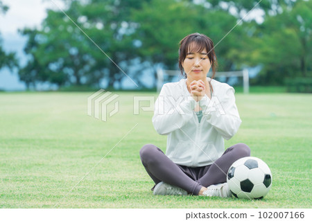 一位日本女性，她是一名足球迷和支持者，為日本國家隊歡呼，彷彿在祈禱 102007166