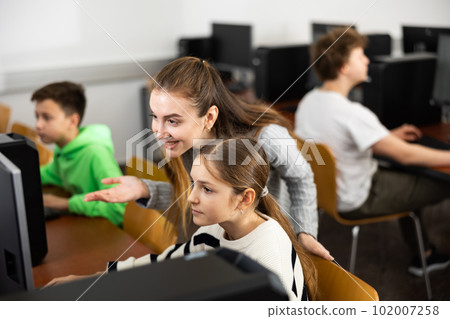 Female teacher consulting teenage girl studying in information technology class 102007258