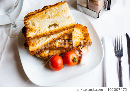 Traditional Catalan food, pan con tomate, served on plate 102007473