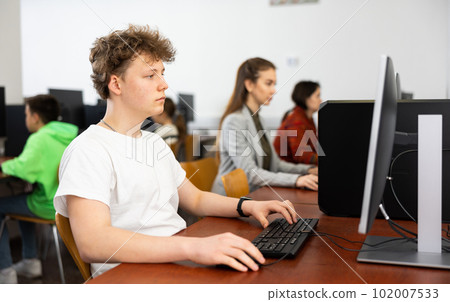Teenage boy using computer during lesson Teenage boy using computer during lesson 102007533