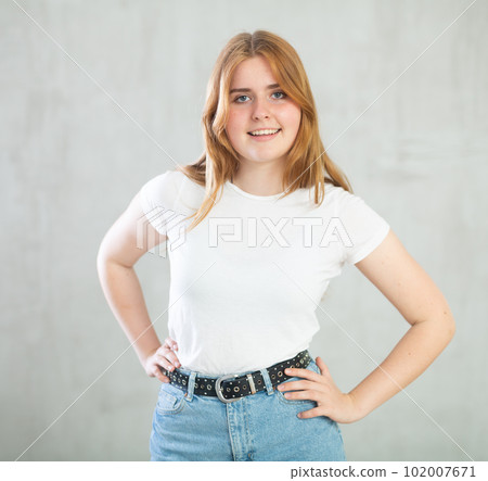 Portrait of beautiful cute cheerful girl smiling looking at camera over grey background 102007671