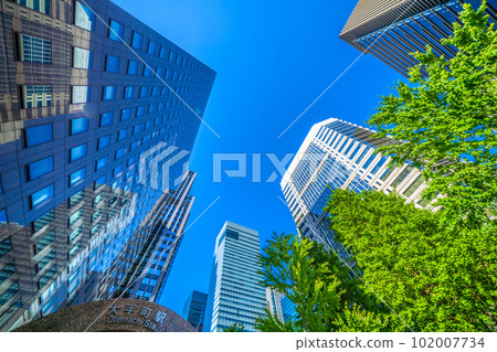 Tokyo cityscape in Japan Sunshine like summer. Otemachi Station in front of the Otemachi intersection and skyscrapers shining in the blue sky and fresh greenery = April 102007734