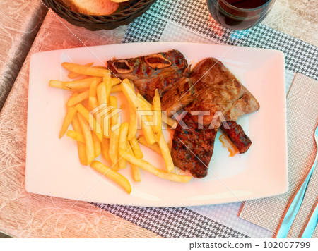 Barbecue meat served with french fries 102007799