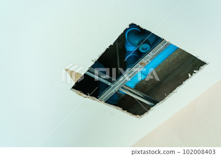 Close up shot at a big hold on ceiling showing water pipe and pumping system. Close up shot at a big hold on ceiling showing water pipe and pumping system. 102008403
