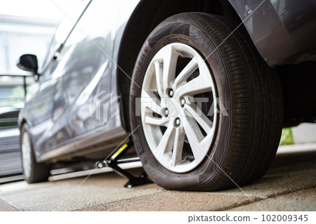 Close up photograph of damaged wheel - flat tire of an accident vehicle. A car have an accident on a wheel. Close up photograph of damaged wheel - flat tire of an accident vehicle. A car have an accident on a wheel. 102009345