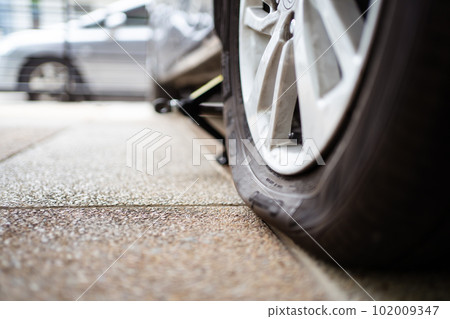 Close up photograph of damaged wheel - flat tire of an accident vehicle. A car have an accident on a wheel. Close up photograph of damaged wheel - flat tire of an accident vehicle. A car have an accident on a wheel. 102009347