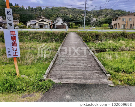 A small bridge without a railing over a rural river A small bridge without a railing over a rural river 102009698
