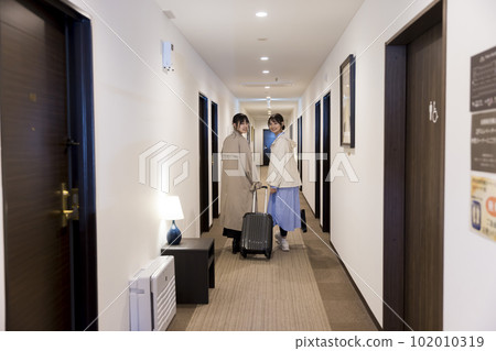 Young women checking in and walking in hotel corridor Young women checking in and walking in hotel corridor 102010319