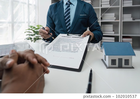 Real estate agent talked about the of the home purchase agreement and asked the customer to sign the documents to make the contract legally, Home sales and home insurance concept 102010537