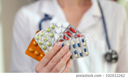 Female doctor holds blisters of pills and vitamins in hand Female doctor holds blisters of pills and vitamins in hand 102012262